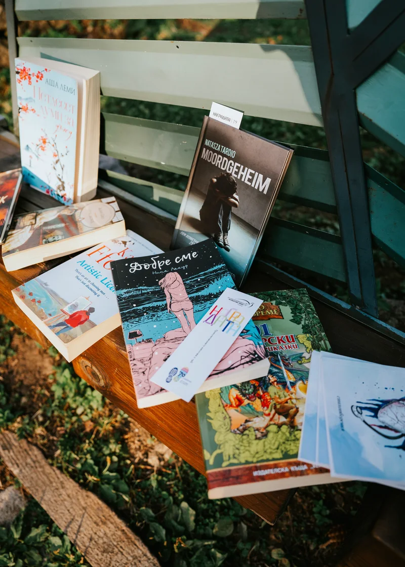 Книги, подредени на дървена пейка на открито