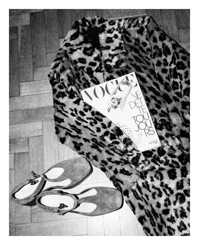 Палто на леопардови петна, списание Vogue и обувки на паркета, черно-бял кадър